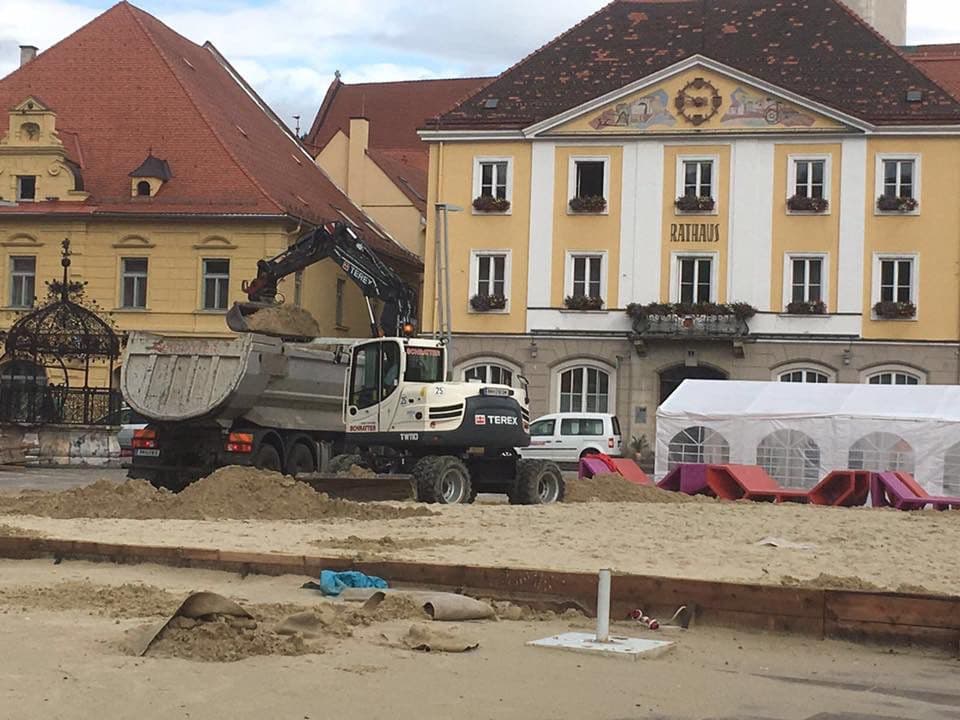 Radbagger mit Ladekran in der Stadt